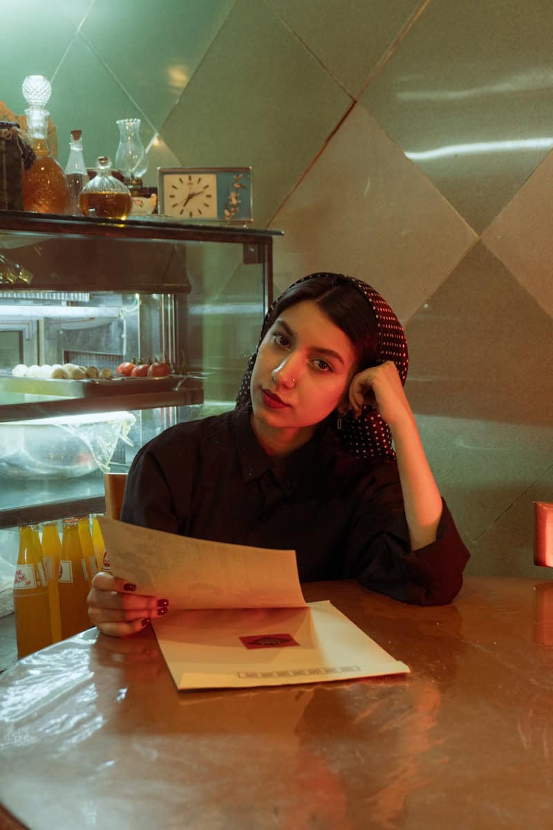 Young woman reads a document at a counter.
