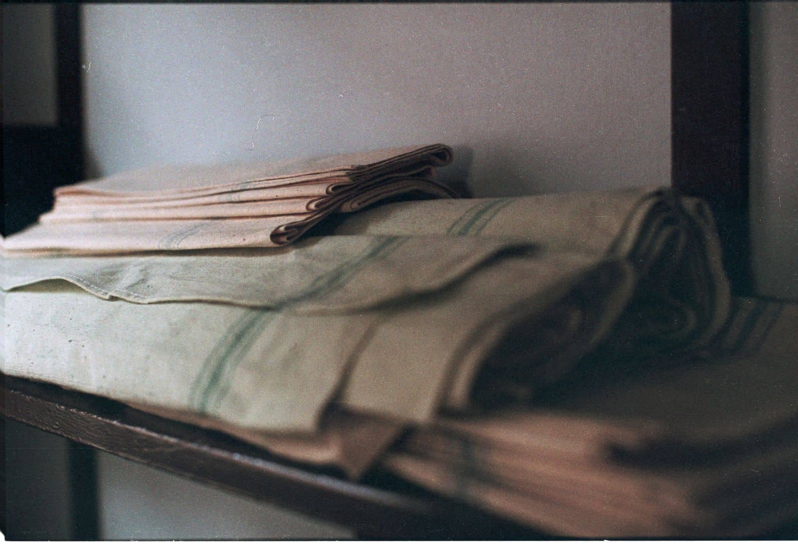 Neatly folded linens stacked on a storage shelf